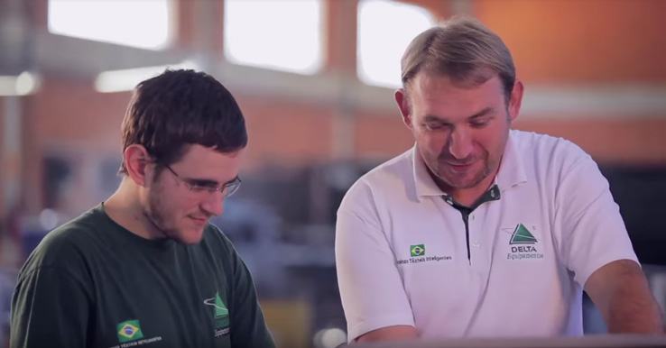 Empleados de una confección recibiendo entrenamiento en la nueva maquinaria de relajamiento de tela de punto.