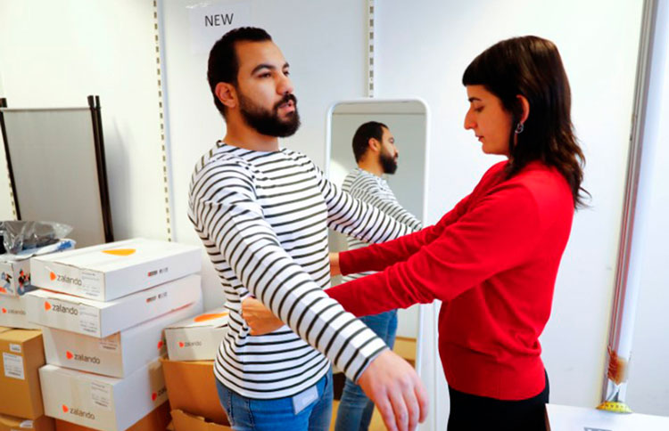 Funcionária da Zalando medindo cliente.